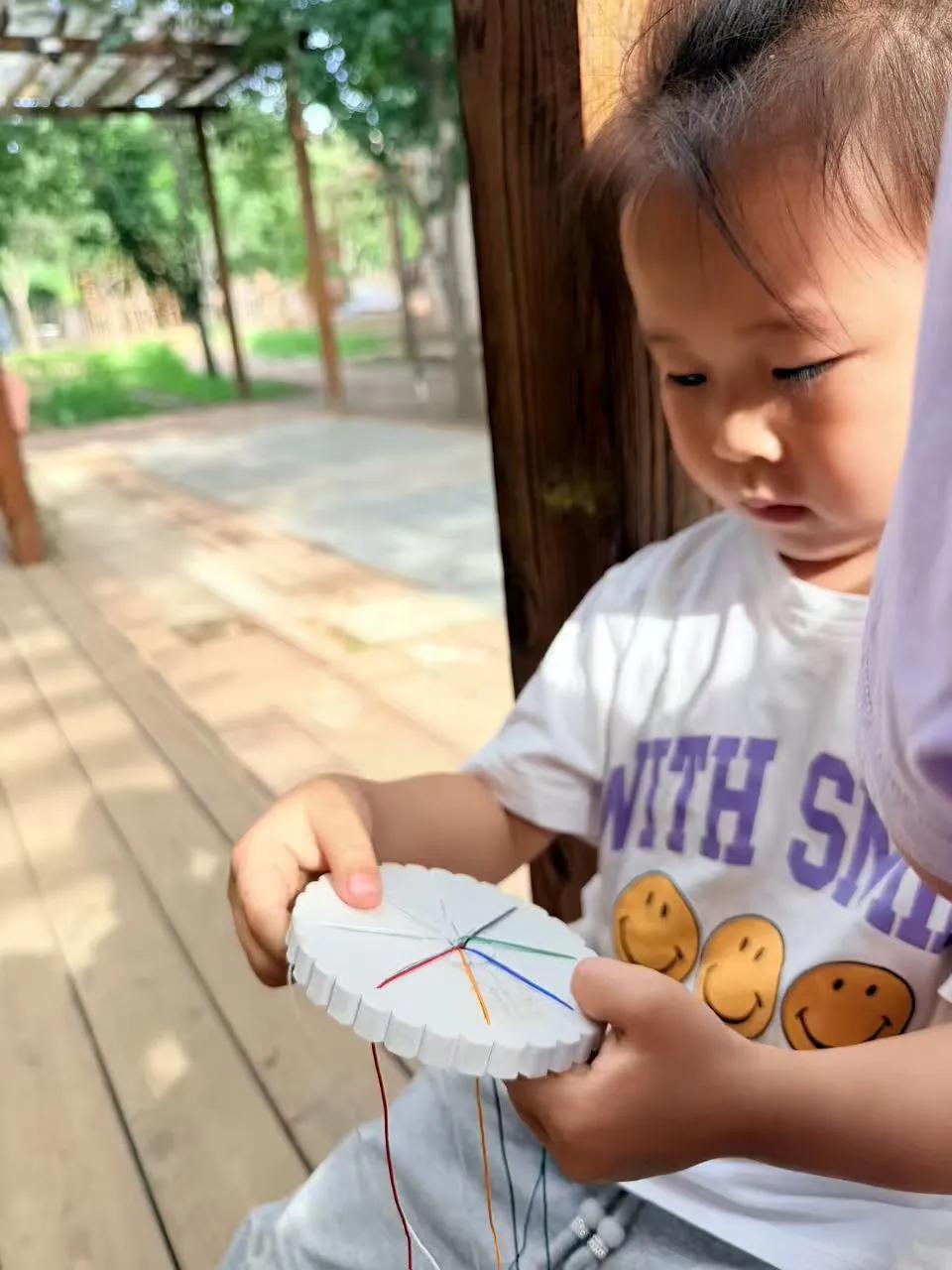 "老师，我的线打结啦！"小雨撅着嘴，彩色丝线在指尖缠成蝴蝶结。我蹲下身，看见她掌