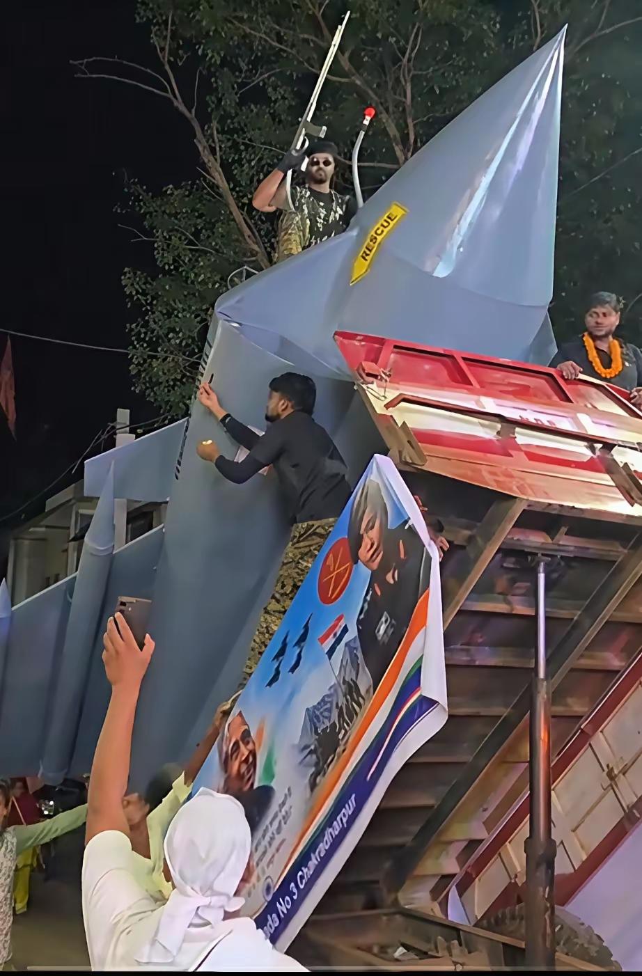 印度民间街头游行，民众抬着手工艺打造的战机模型，敲锣打鼓、载歌载舞，大肆展示属于