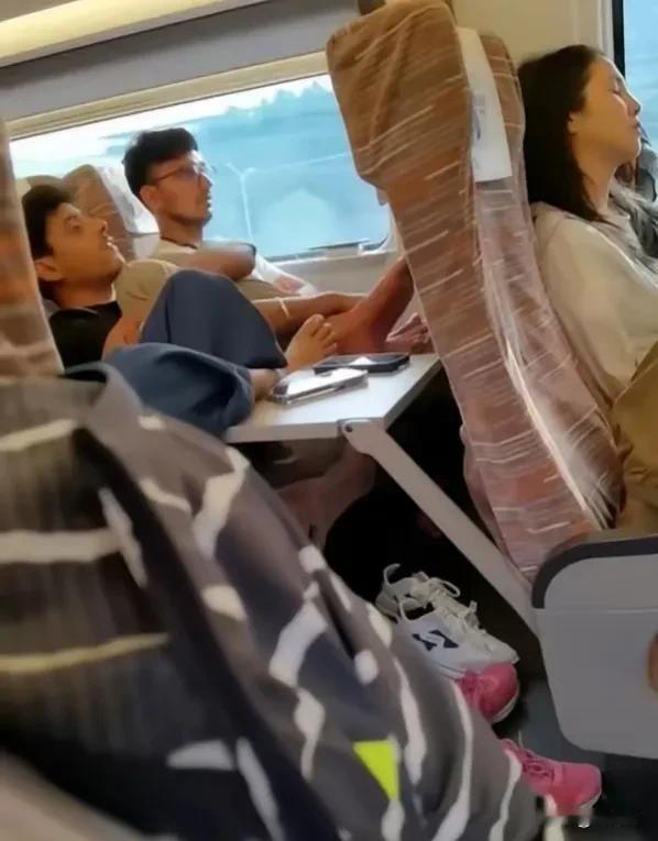 北京一名网友在乘坐高铁时，发现同车厢有几名印度乘客脱鞋光脚，并将脚踩在桌板上，同