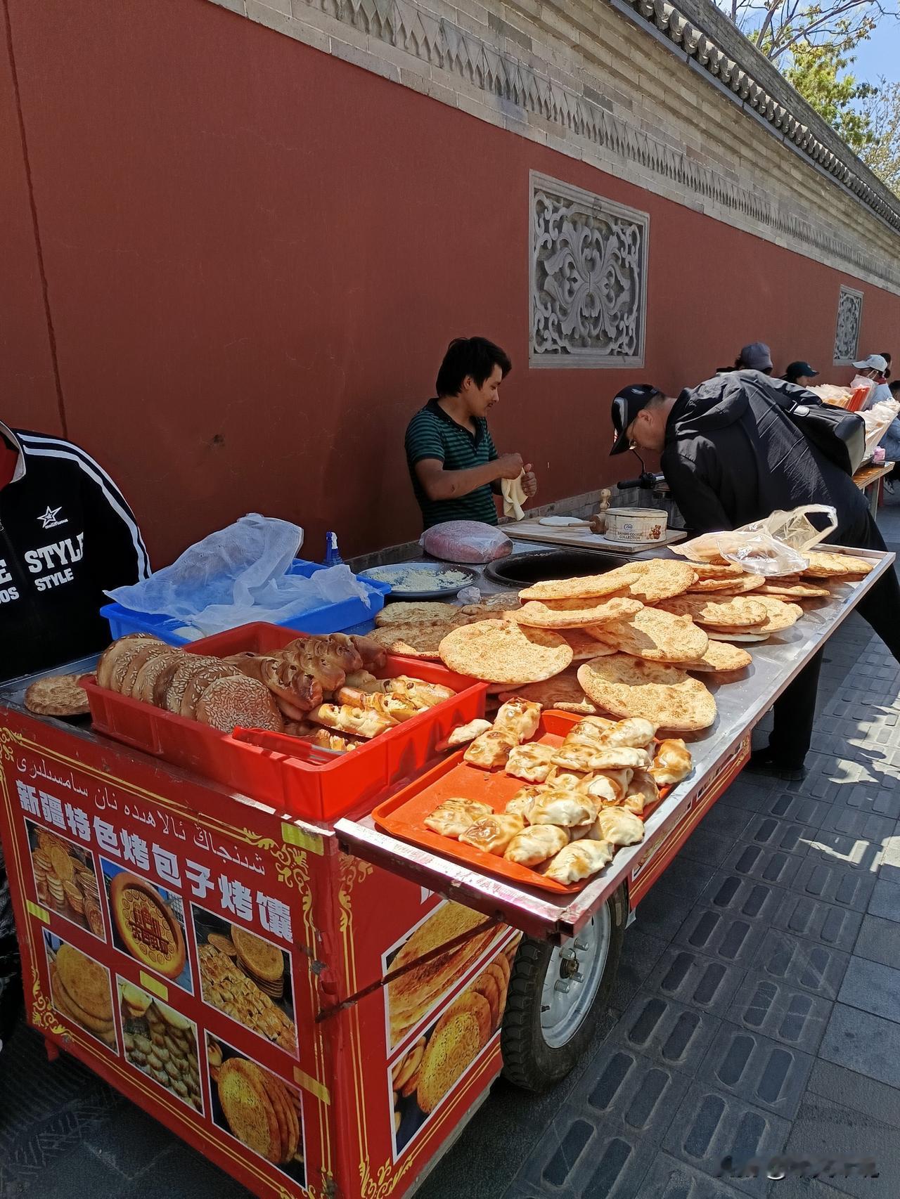 墙里梵音墙外叫卖。

红墙根底下摆摊，这是哪里啊？这是大同华严寺的外墙。五一小长