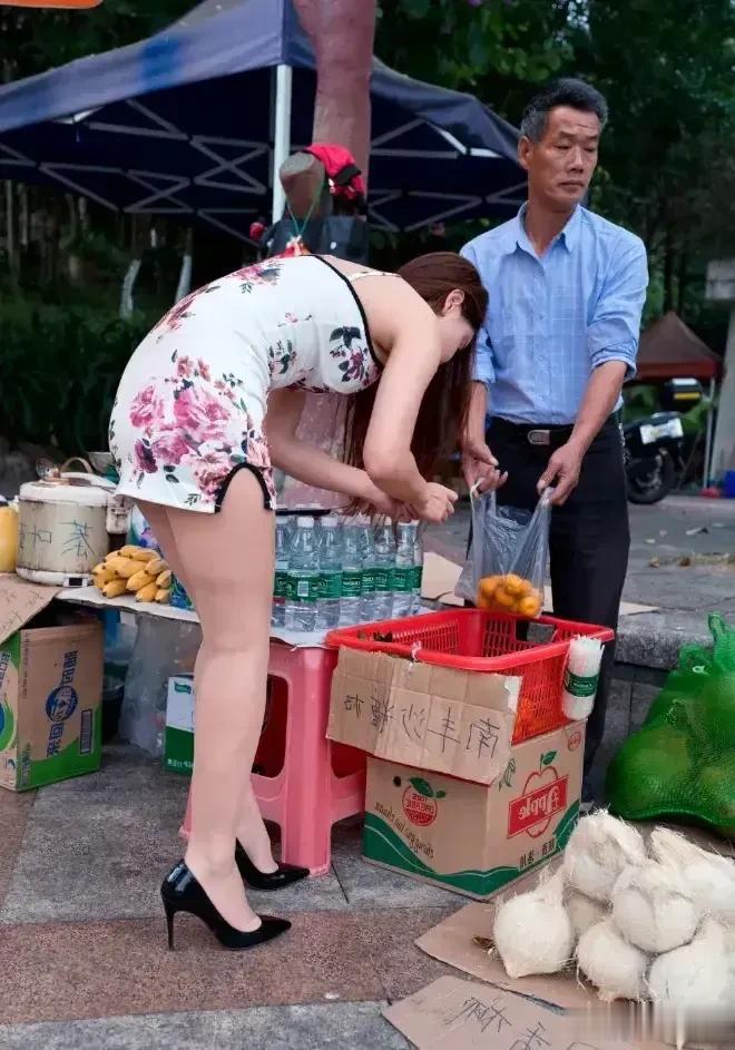一位身材匀称，打扮漂亮的美女路过一个摊位，女人看见贩卖的是南丰砂糖橘子，想买几斤