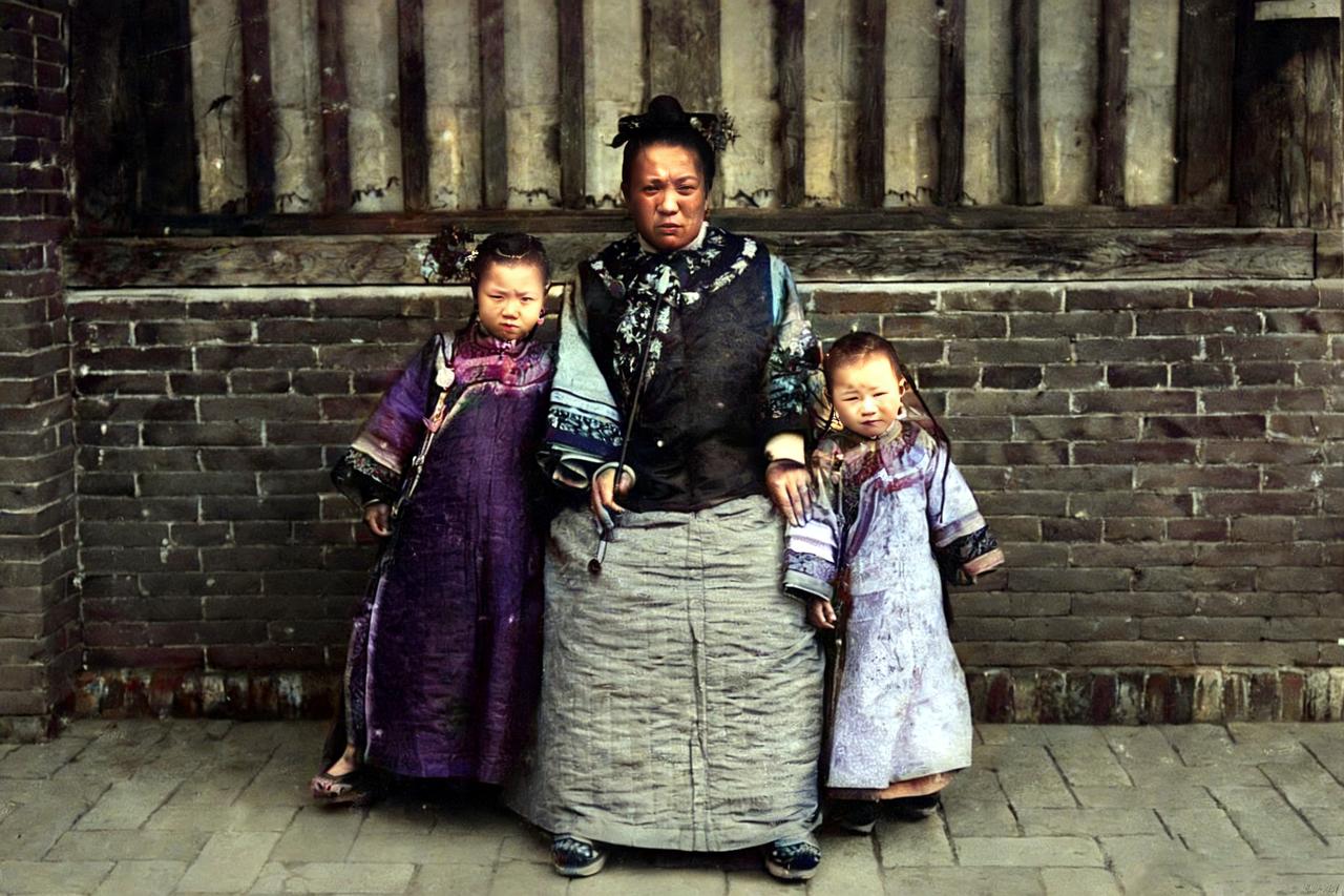 1900年，辽宁奉天附近一户满族人家母女三人的合影。

母亲手里拿着标志性的大烟