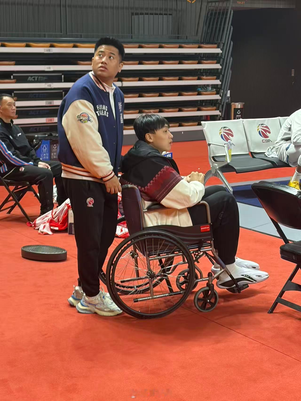即便自己因伤暂别赛场，齐麟的心却始终与球队在一起。他坐着轮椅来到场边，与球队并肩