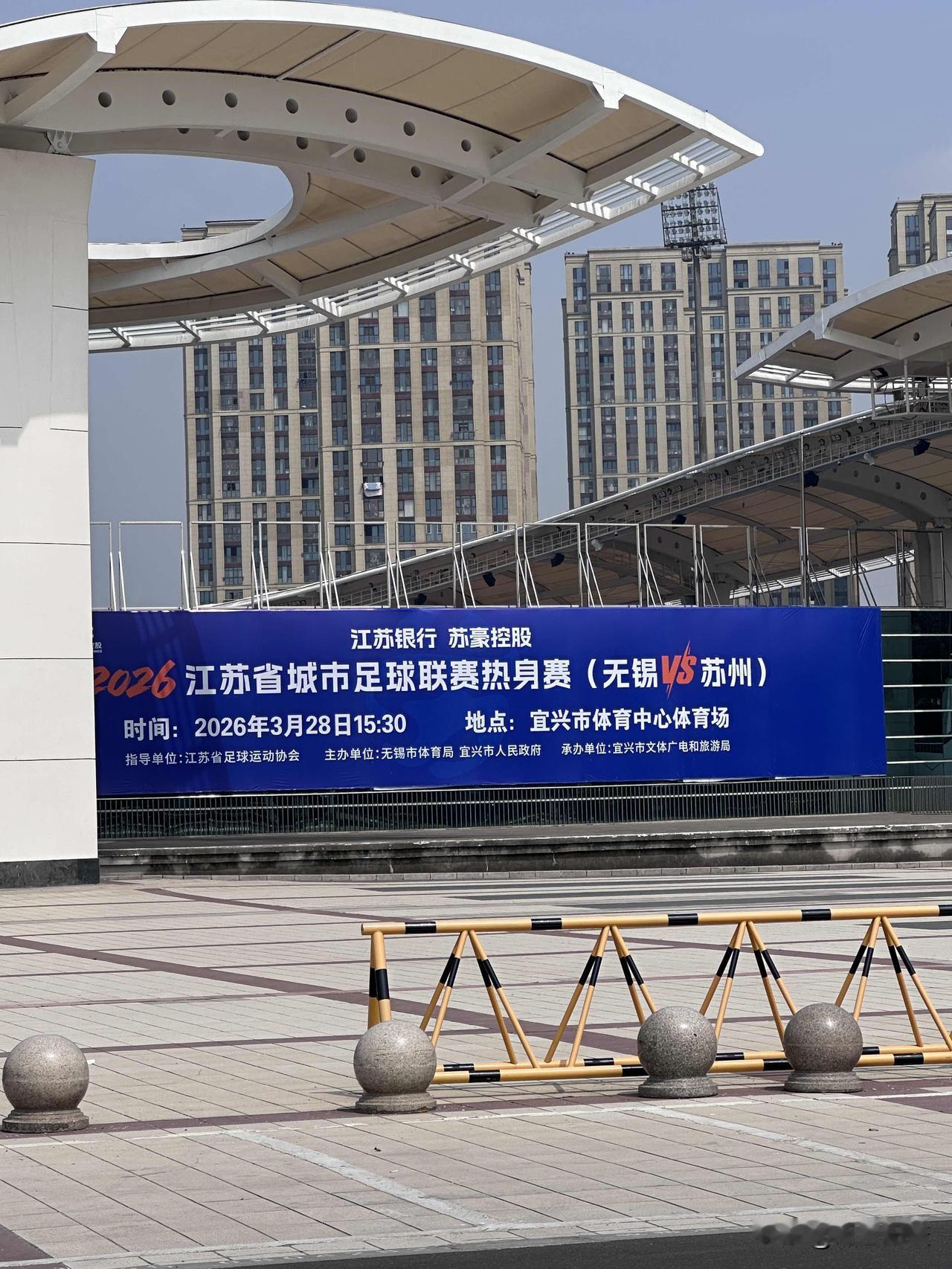 闲逛到宜兴体育中心，门口挂起了苏超热身赛的横幅。明天下午将在这里举办（无锡VS苏