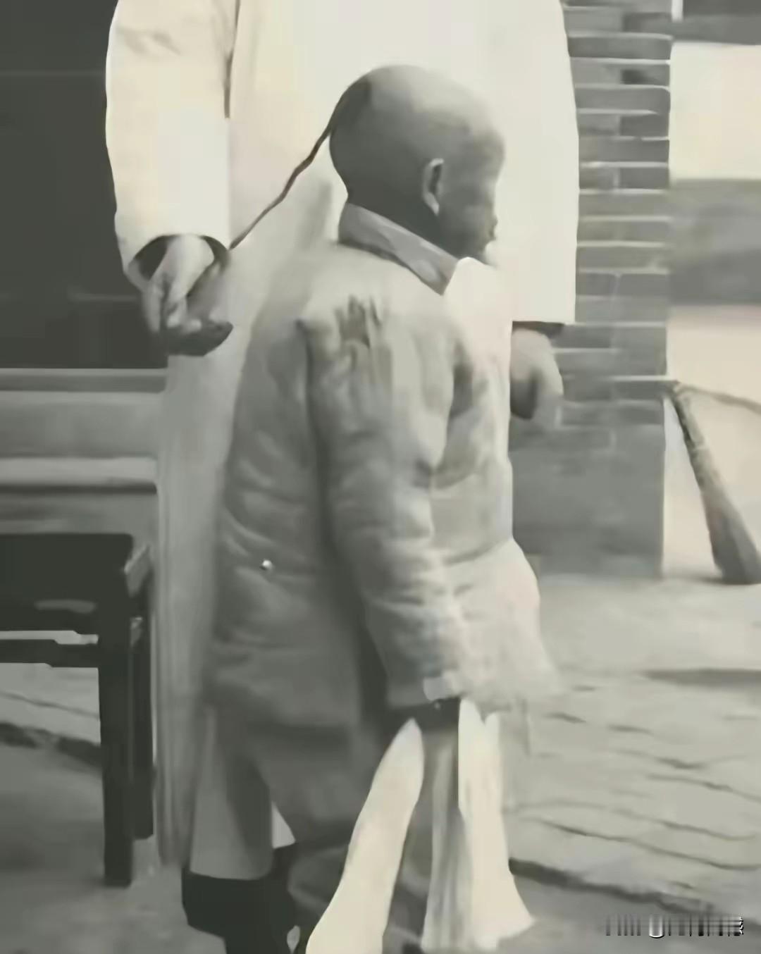 这就是传说中的金钱鼠尾辫，整个人仅仅后脑勺留一块头发，辫子特别的细，据说能够从铜