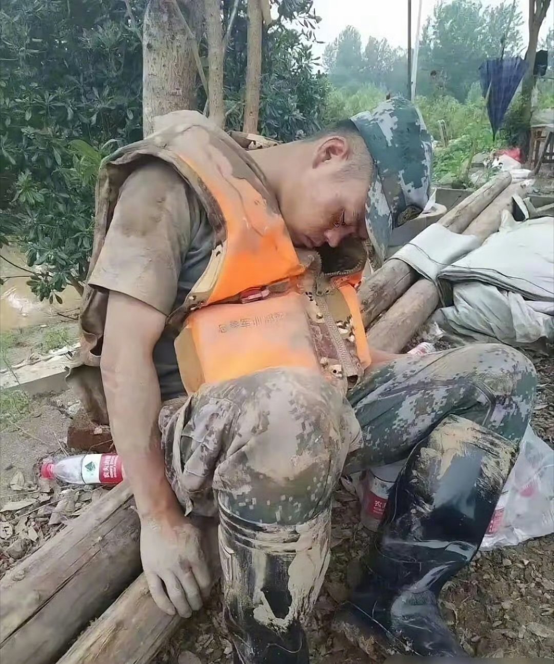 刷到这张照片真的破防了——一个浑身泥浆的兵哥哥，靠在树上就睡着了，连橙色救生衣都