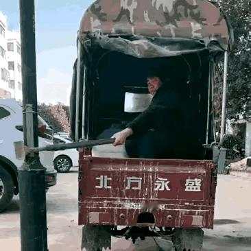 大姐要求坐副驾驶被拒，心生不满的她把锄头勾住路边的电线杆，不明就里的大爷怎么也开