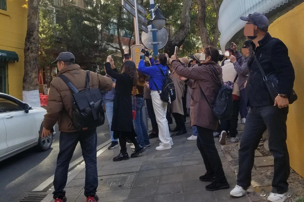 这是在昆明黄公东街看到的一幕，一群年龄相仿的游客模样的男女，集体举起各自的手机，