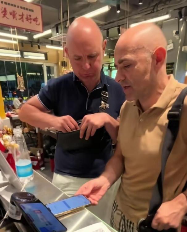 出门在外难免碰上窘境，两名外国游客在南昌品尝烧烤，结账时既没法扫码，身上也没有人