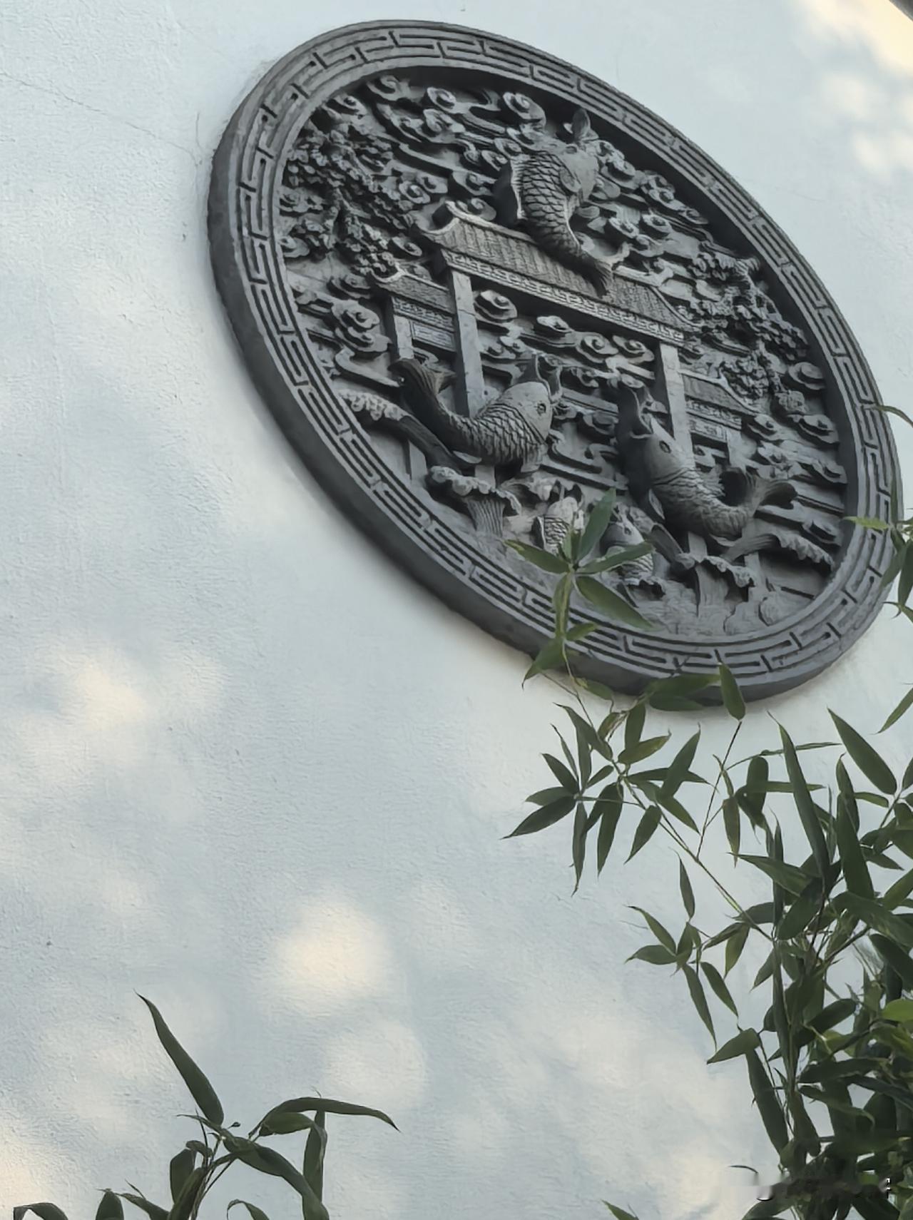 仔细一看，几条鲤鱼向着龙门奋力腾跃，祥云、浪花环绕四周，雕工细细密密，古朴又耐看