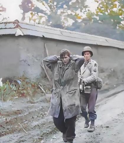 1945年， 美军士兵正在押解德军女战俘。这名女兵身高足有1米75，留着利落短发