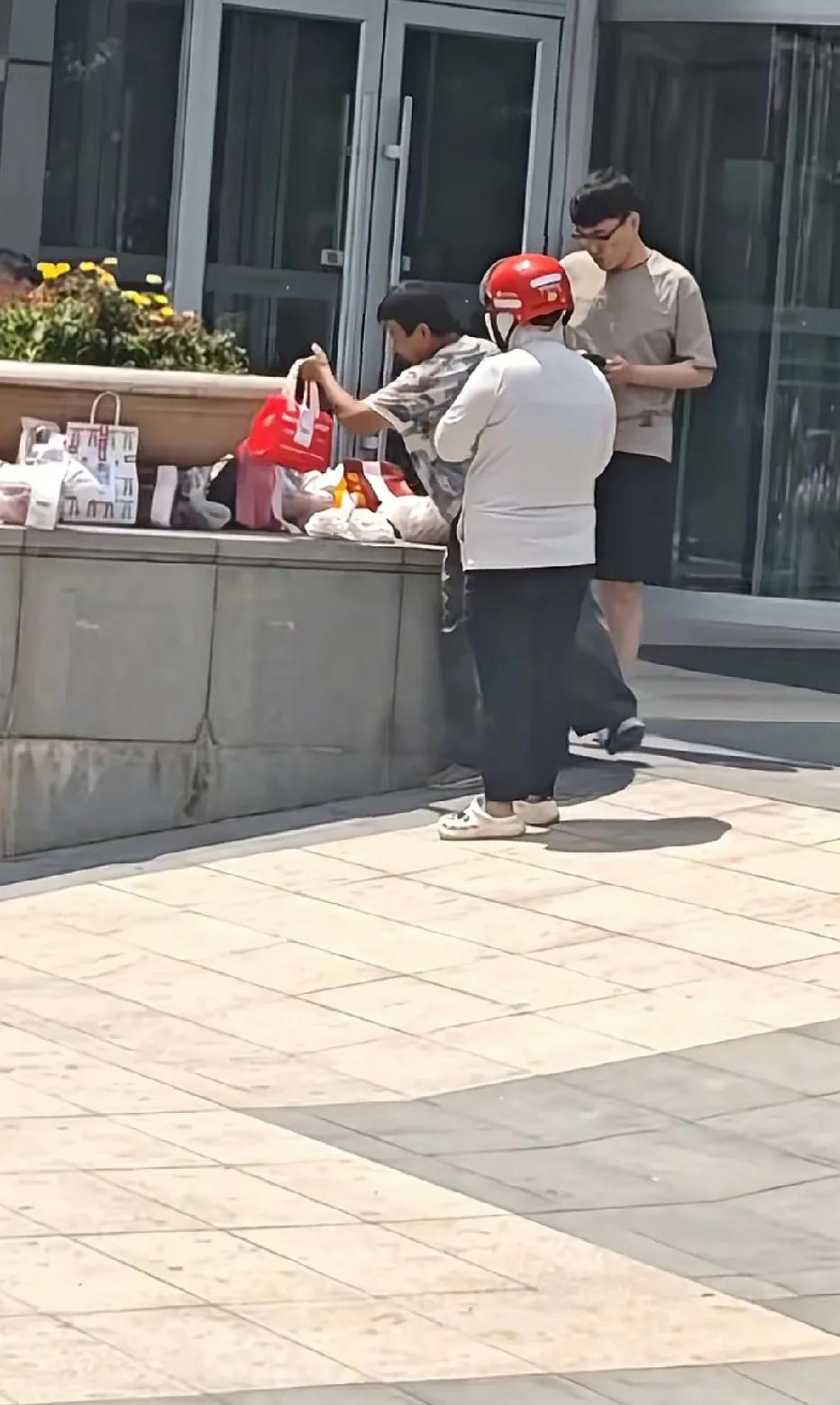 辽宁沈阳，大妈在某办公楼蹲点，看到外卖哥把外卖餐放在桌面上，大妈趁外卖哥不注意，