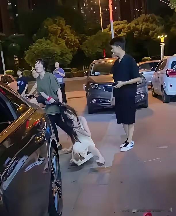 原配打小三，老公冷观
这一幕着实让人气愤，穿白裙的女子，被原配拉着头发，拖着在地