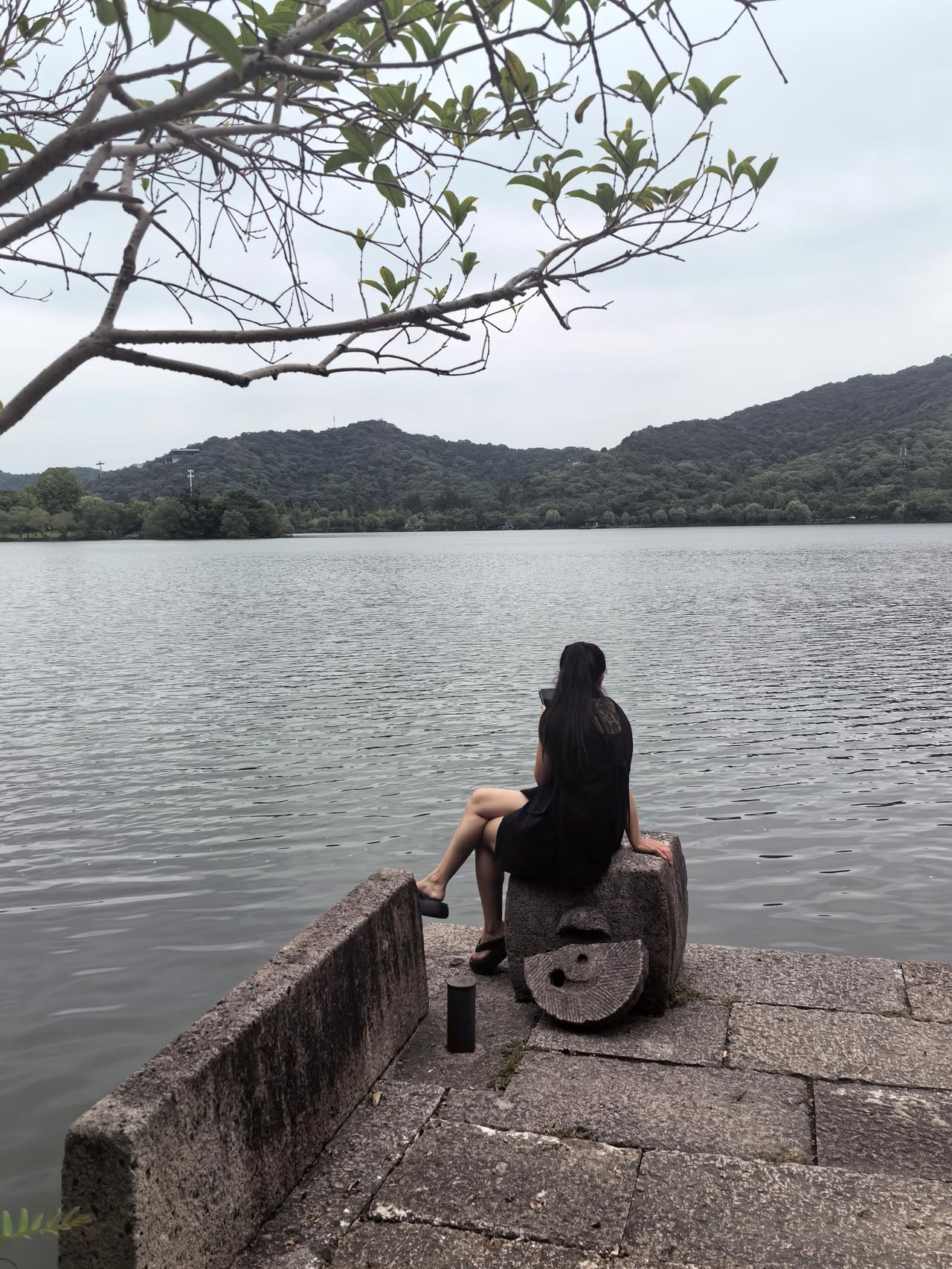 【湘湖边的少女】
 
湘湖的风总带着水汽，拂过石阶时，撞见一袭黑裙、长发飘飘的少