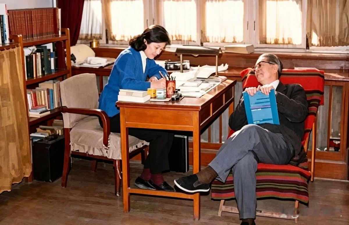 1974年，外交家乔冠华斜倚在椅子上，看着伏案工作的妻子章含之微笑。
一个在写，