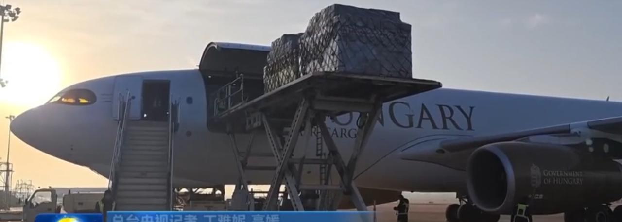 晨曦中的机场，匈牙利货机舱门大开，包裹正被有序装载。仓库里，叉车穿梭往来，纸箱堆