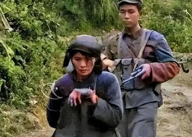 1979年老山战役中，一个军队的士兵正押着个越南女俘虏，走在回营地的道上。在被押