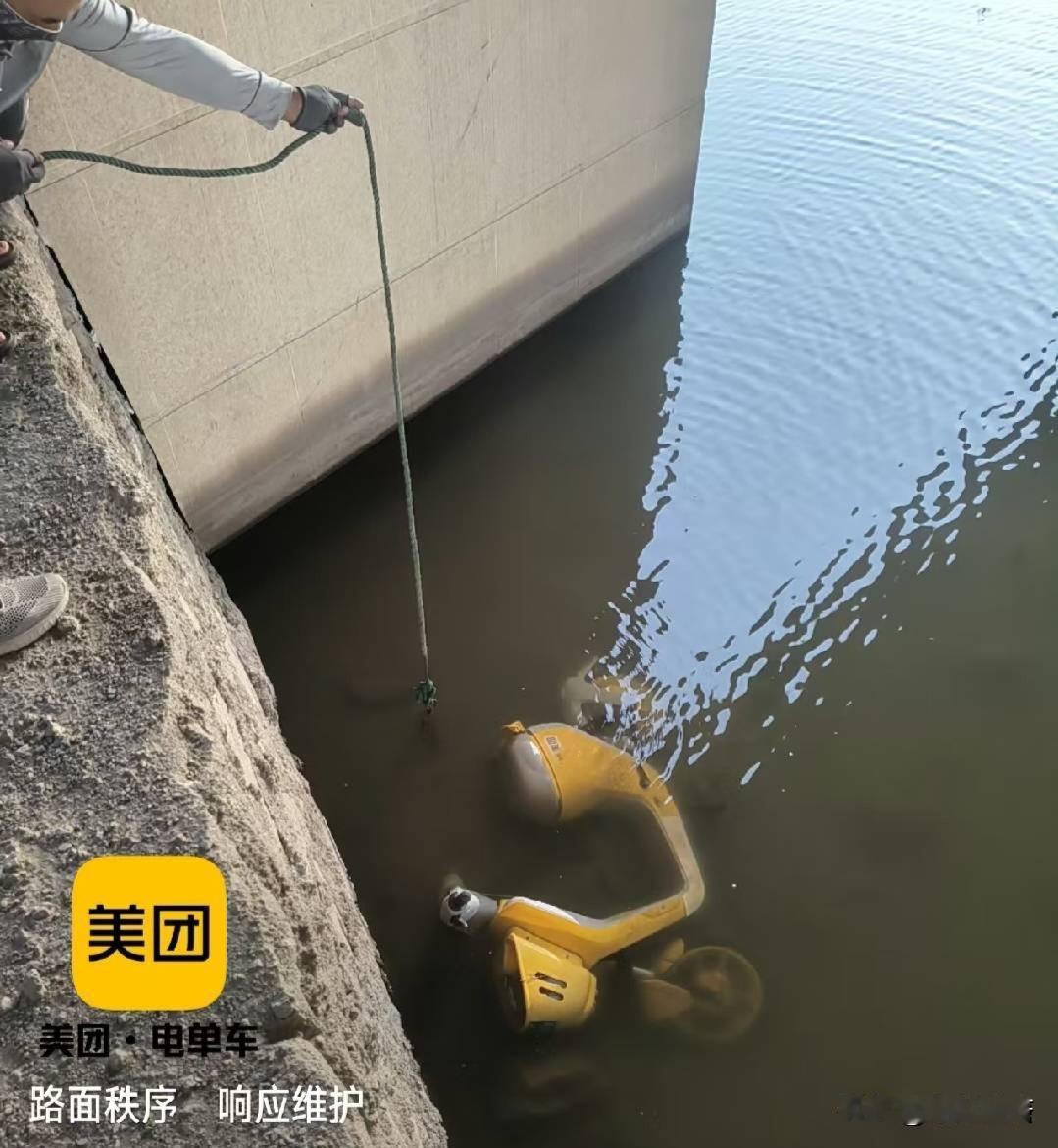 夏日生活打卡季洪洞滨河公园桥下，一辆美团共享小黄车遭人恶意丢入汾河，工作人员耗时