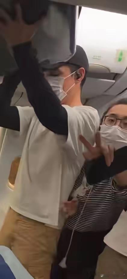 胡歌在飞机上被拍了，但这次挡镜头的不是保安，是他老婆。 