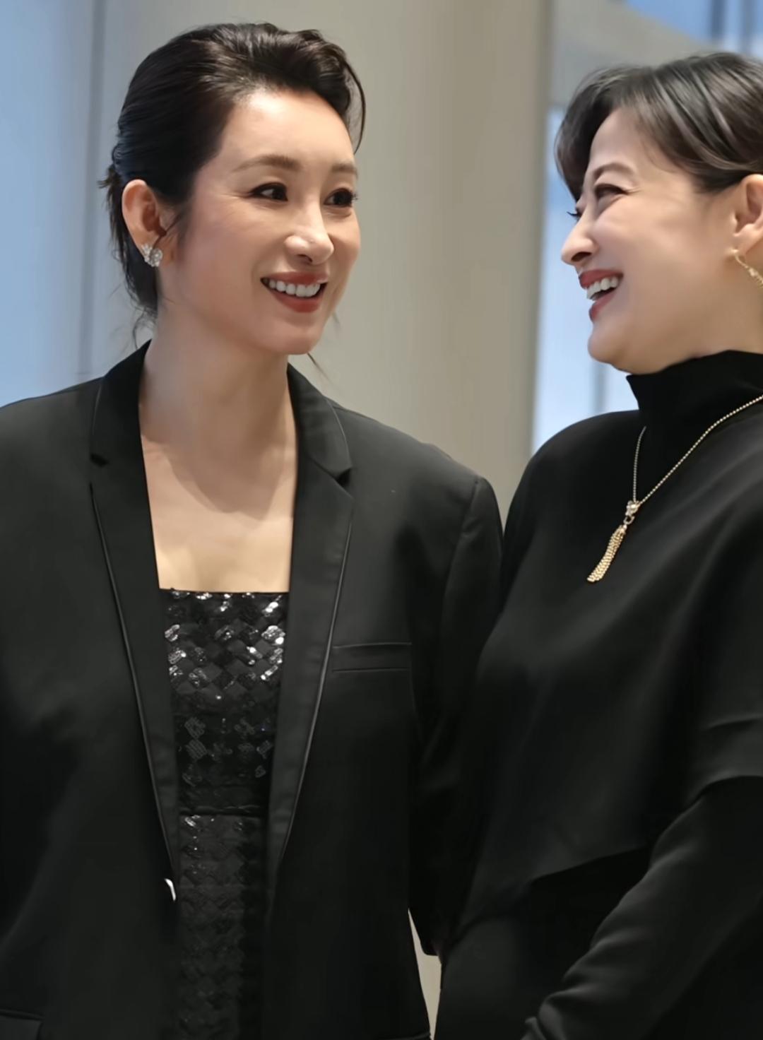 两位女士穿着时尚，微笑交谈。还是那么优雅。两位女士很绅士。能叫上名字的不多吧？永