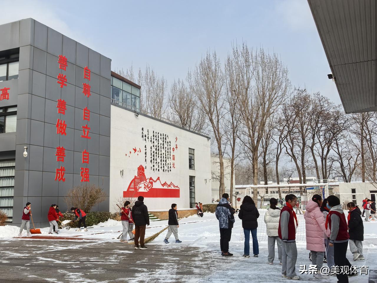 清理校园内积雪的延庆第四小学（南校区）的小学生。