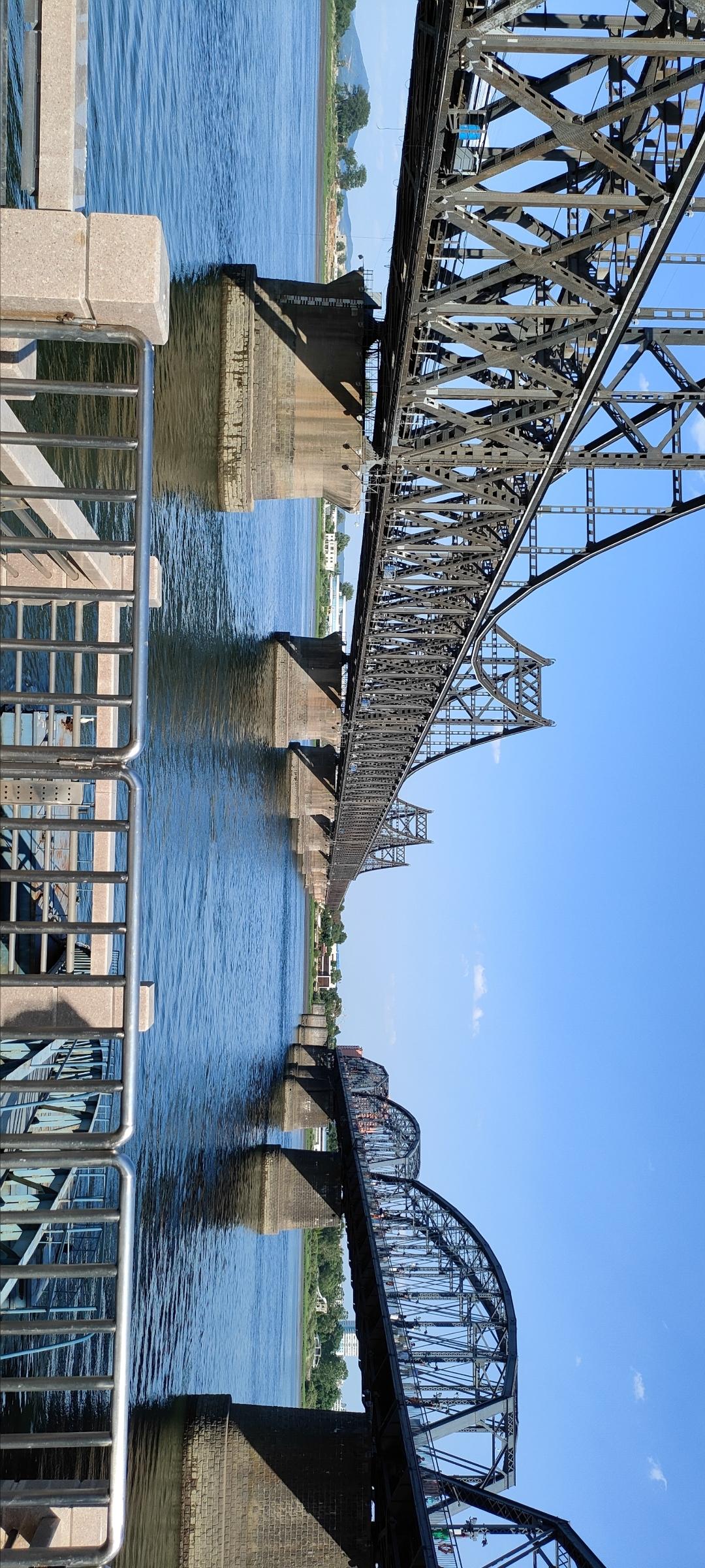 横跨河流的铁桥，静谧的蓝天下，感受历史的厚重与现代的交汇。