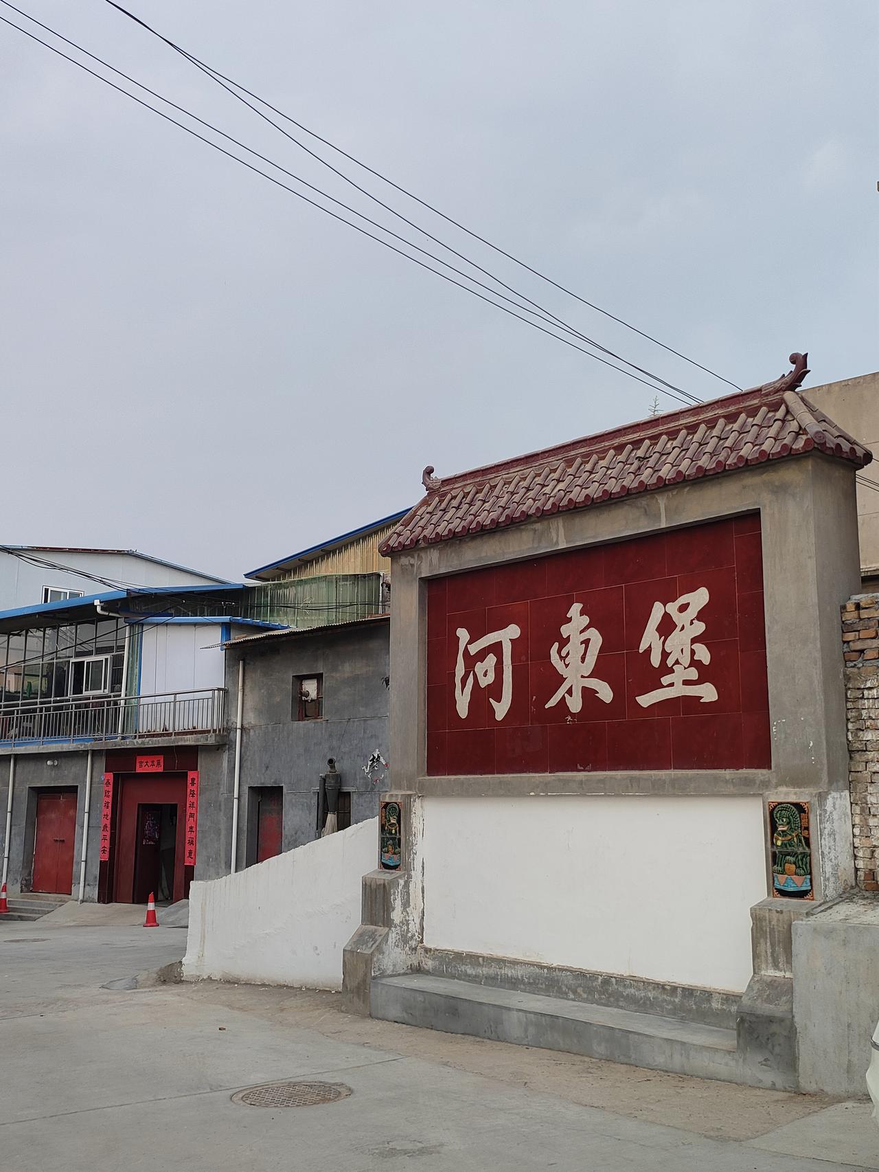夏日随手拍踏入河东堡，红墙白瓦刻着村落印记。村口老树扎根多年，枝叶衬着黄昏流云，