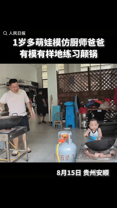 “1岁多萌娃火到人民日报了！”贵州安顺，一爸爸在厨房炒菜，旁边灶台上还摆着一口空