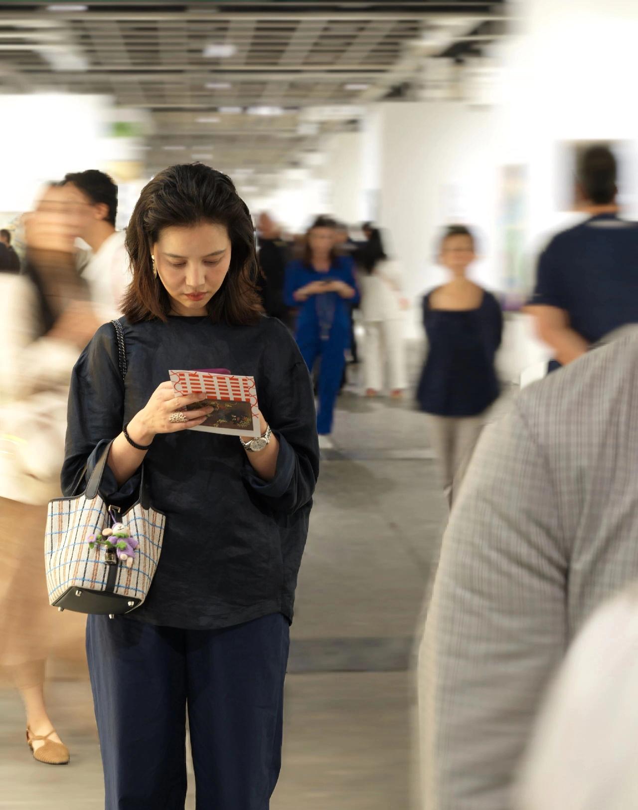 街拍之流动的风景线，在艺术展上，她专注地欣赏着画作，仿佛时间静止。气质美女，到哪