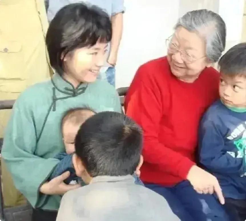 画面中慈祥和蔼的老人是刘思齐，据说，身边的漂亮女孩是扮演她的演员，来她的家中学习