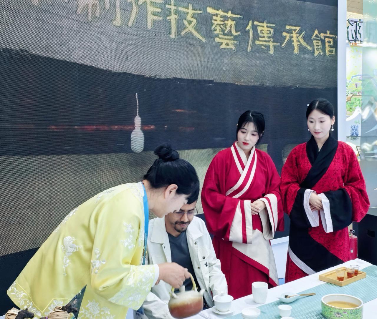 黄衫素手倾出半盏春，琥珀色的茶汤撞入白瓷碗里，红衫人静立檐下，暖香风卷着千年茶意