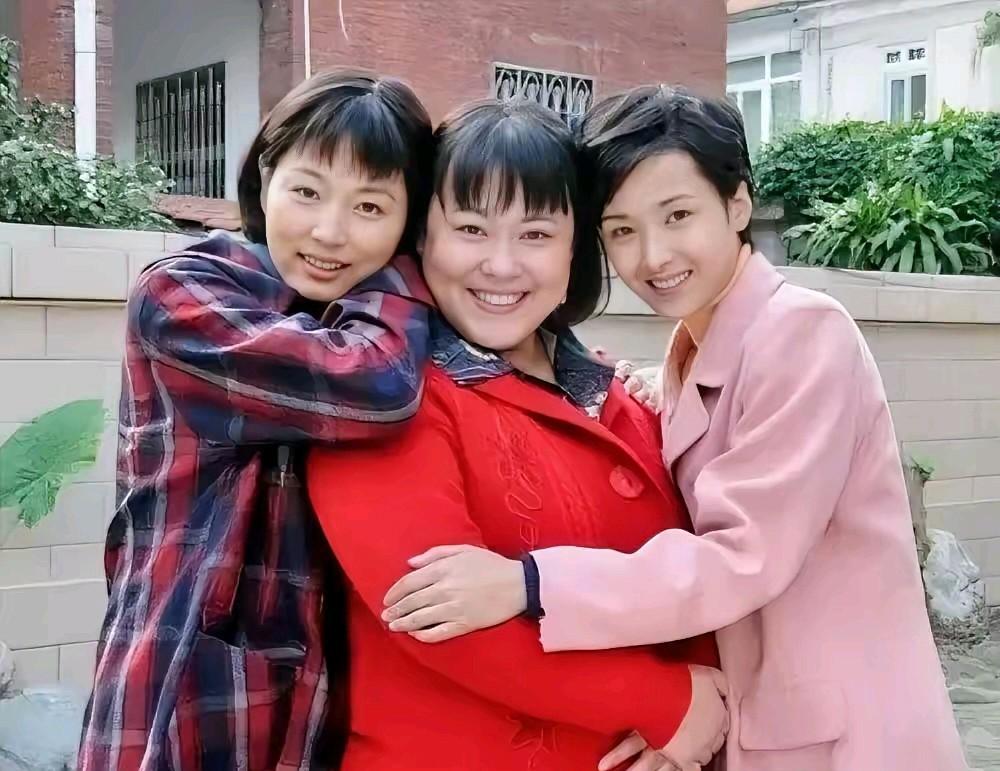 中间这位笑容满面，身着红色衣裳，显得格外喜庆。她是李青青吗？看着有些相似，却又不