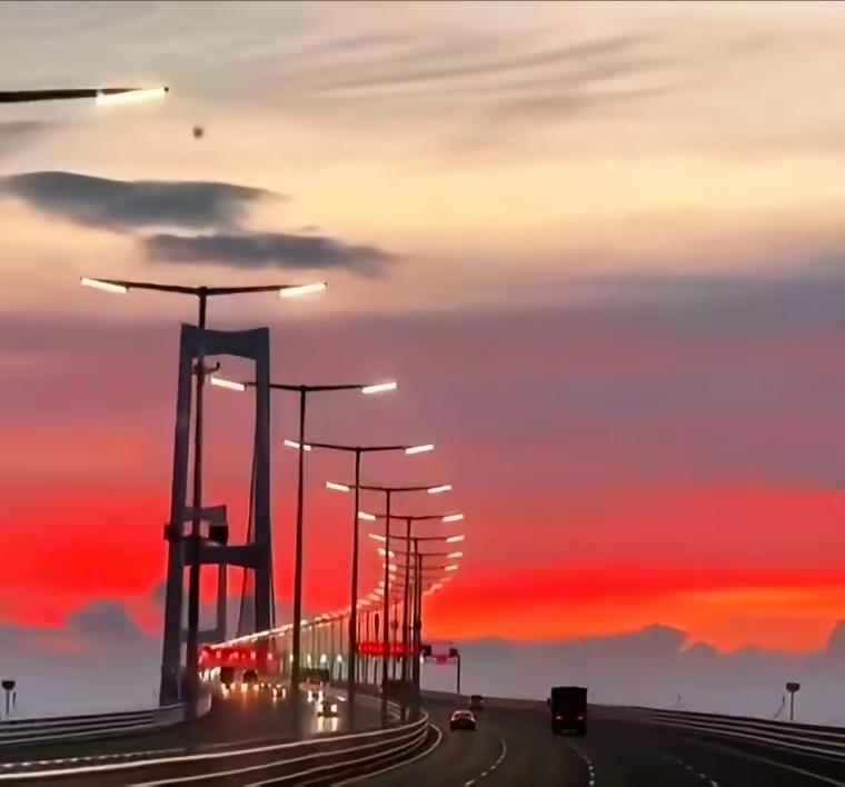 长桥卧浪接天红，
灯列星垂引夜鸿。
车影流光驰向远，
五彩霞光彩色屏。