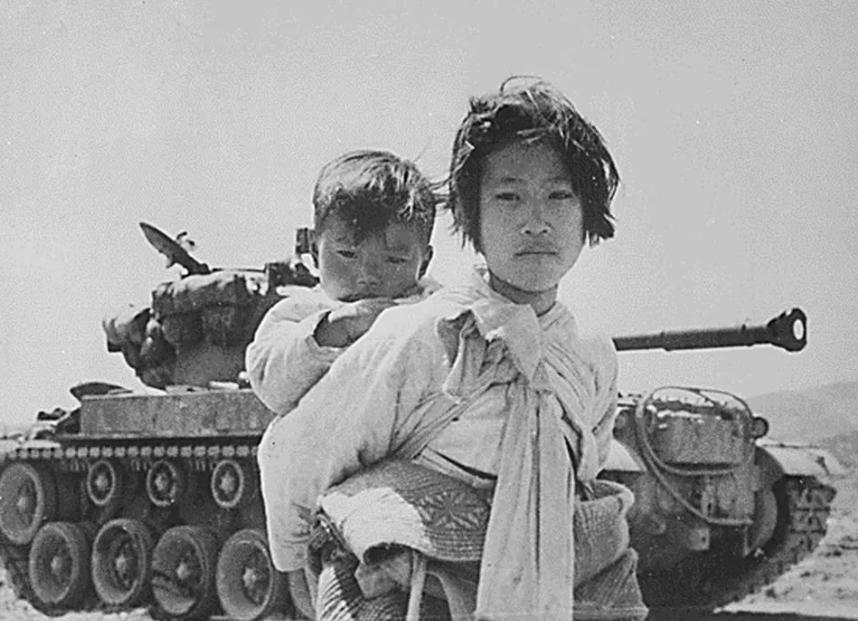 1952年，一名南朝鲜女子给两名美军做完服务后，当着老公的面热情地送大兵们离开。