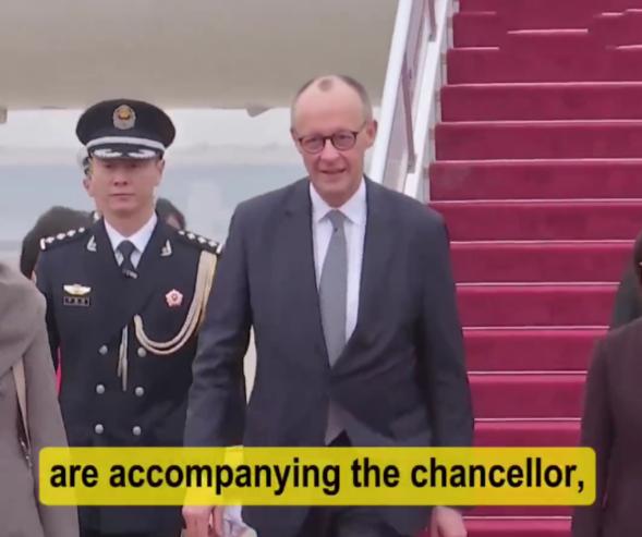 2月25日德国总理抵达访华第一站受到隆重欢迎，走在机场的红毯上，一位穿着军装的兵