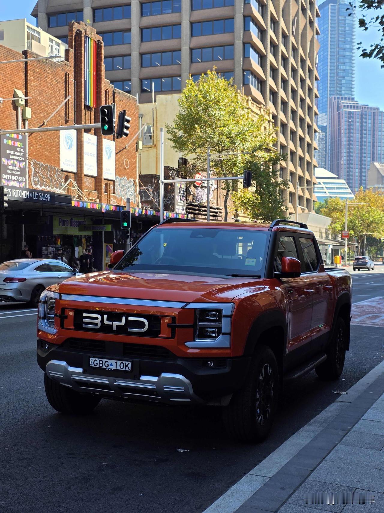 国外街头的这台比亚迪鲨鱼皮卡，也太好看了吧！
方盒子的硬朗造型，配上亮眼的橙色车