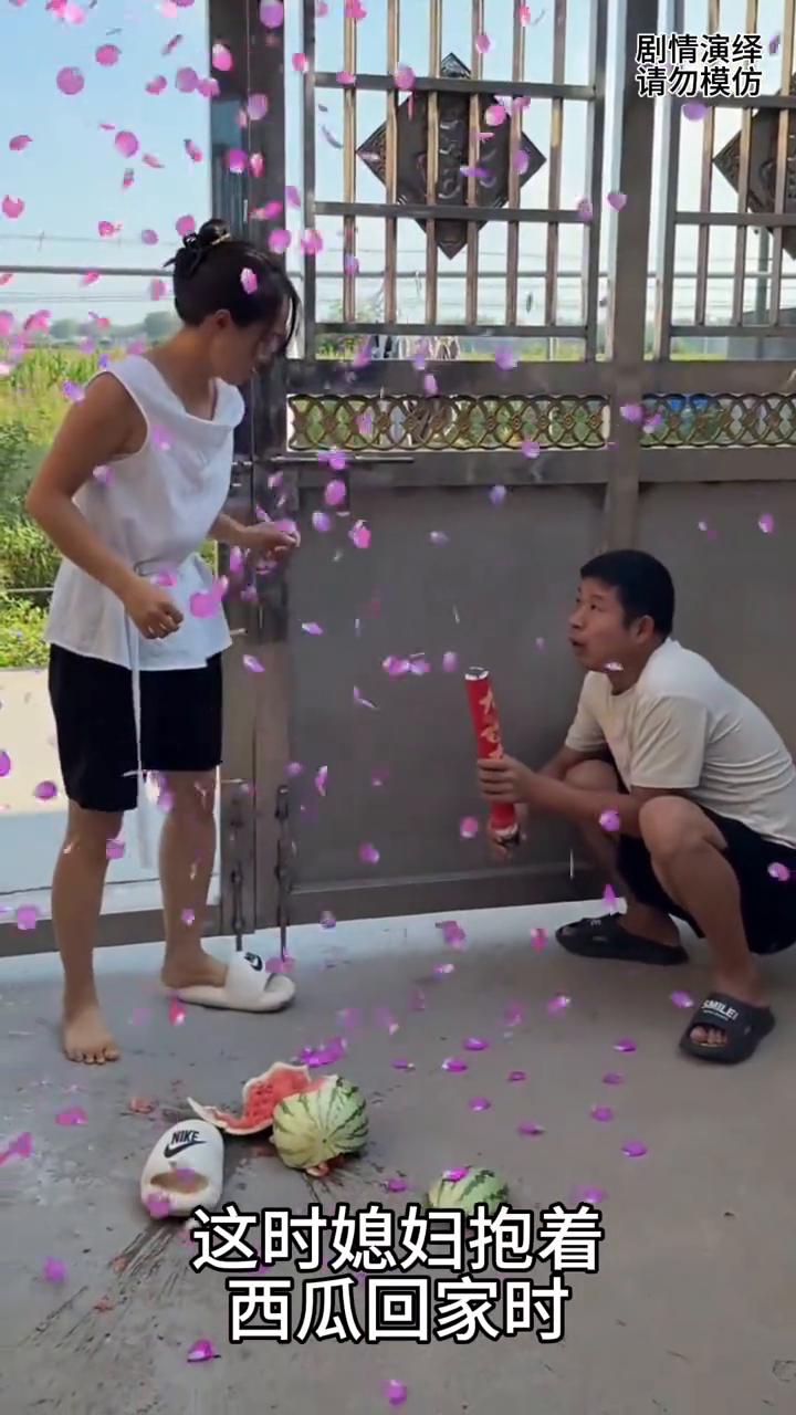 男子拿着礼花筒等老婆回家，这时媳妇抱着西瓜回家时，丈夫打开礼花筒吓了他一跳，这一