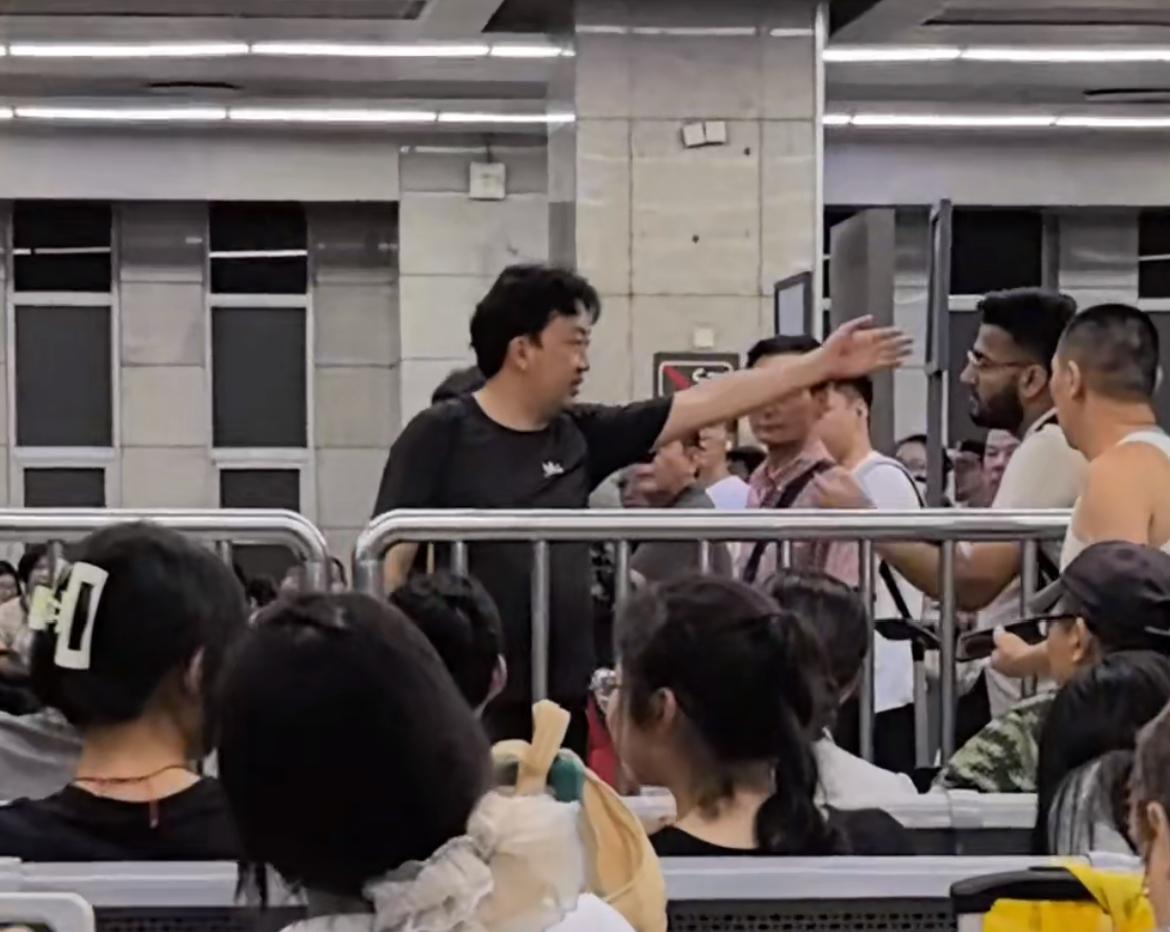 面对外国人要插队，这个大哥硬气，直接叫他去后面排队。某火车站，一个样貌像南亚人的