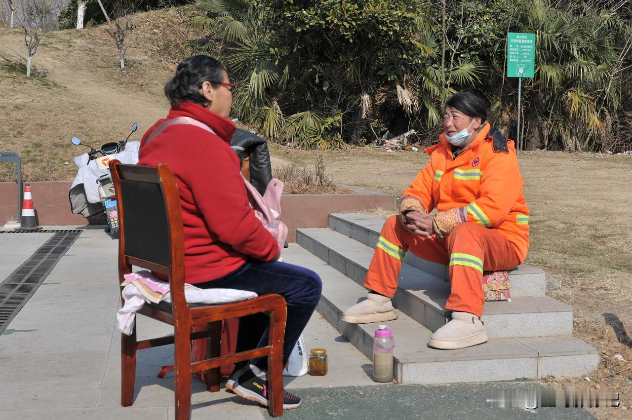 公共场所专职保洁大姐和一位女子在晒太阳聊天。我试试能不能敢不敢拍一张。