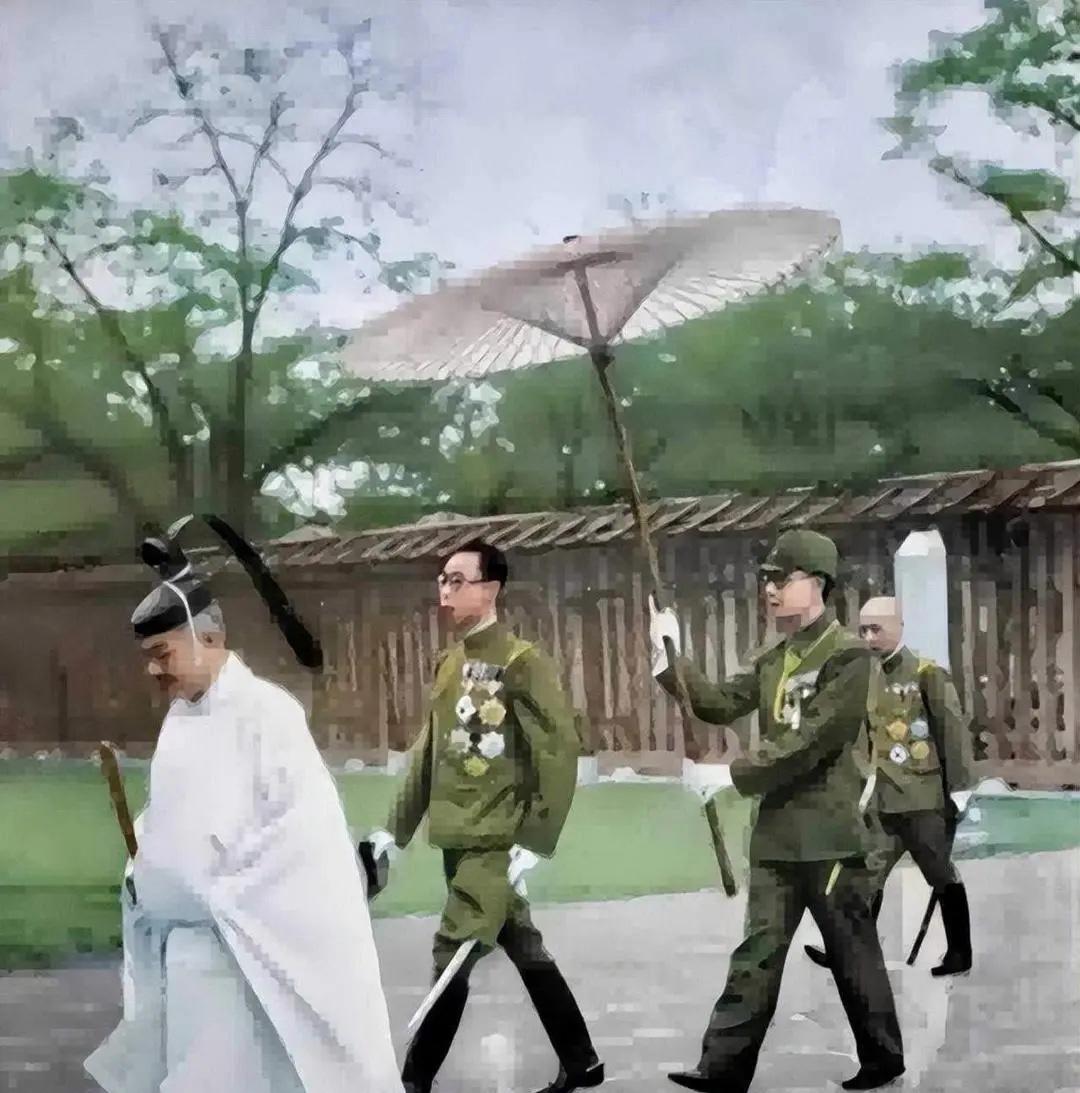 1935年，29岁的溥仪在日本访问时的一张留影，看起来排场很大，有人引路，有军官