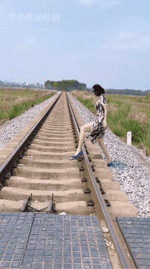 在这前不着村，
后不着店的铁路上，
她穿着旗袍和高跟鞋也真是不方便，
她横穿铁路