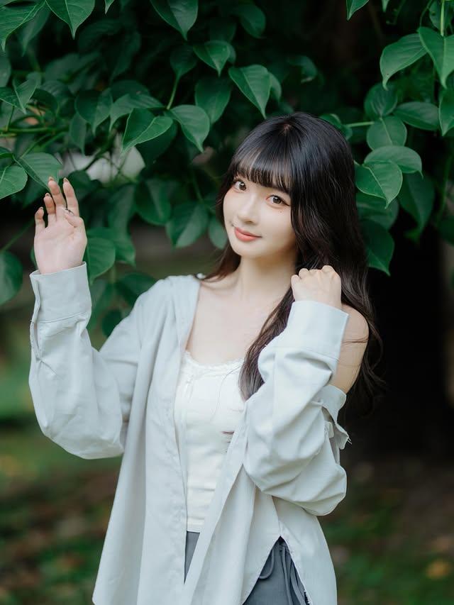 元气少女在绿叶丛中，微笑挥手，清新自然！🌿😊最美的女生长什么样呢