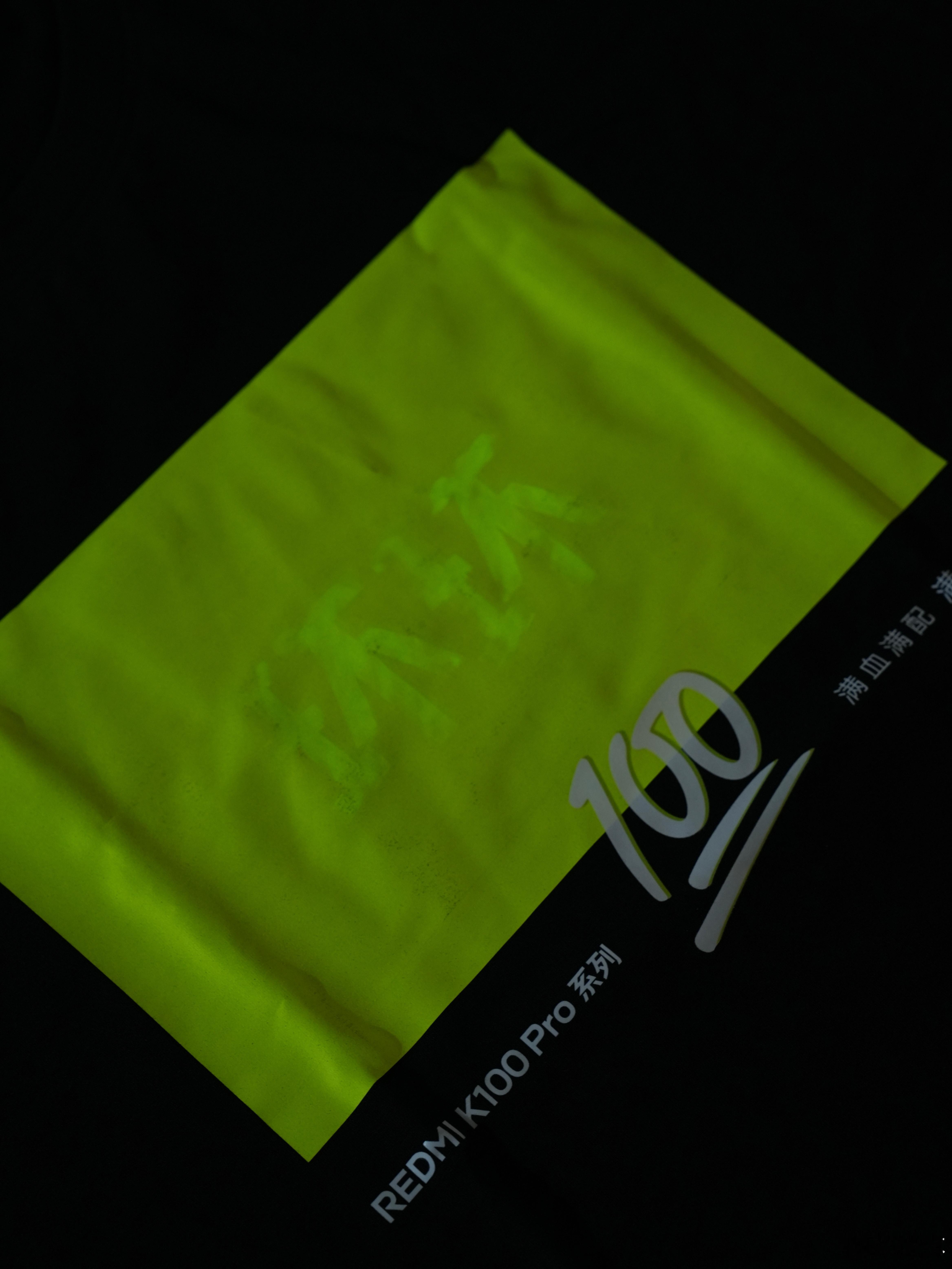 REDMI K100的邀请函是个荧光礼盒，里面除了有荧光短袖，还有几张DIY的小