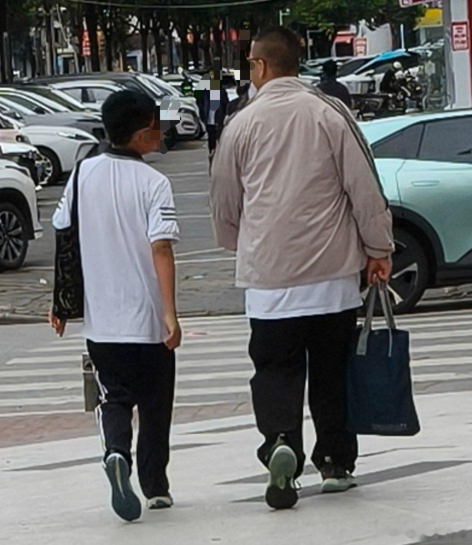 开车路过时看背影以为是父子，等开到他们前面转过来看才发现是两戴红领巾的小学生，而