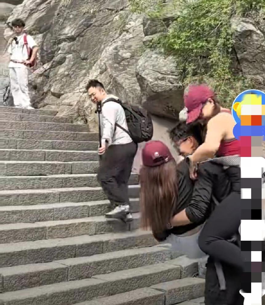 笔陡的石级，人们艰难前行。
       可这位小伙居然背着两个女孩拾级而上！他