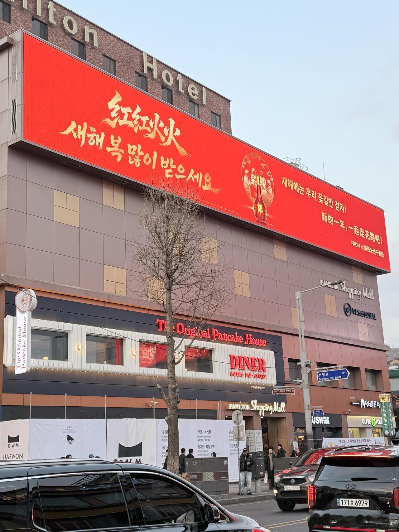 中国游客在首尔梨泰院惊讶发现郎酒大屏广告和大广告牌，韩国人很少用大红色，所以显得