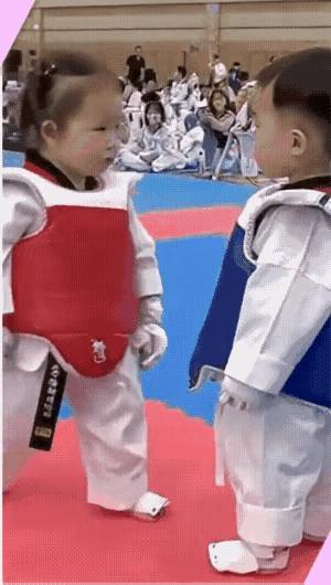 小孩跆拳道比赛太有趣了，这个小女孩遇到一个小帅哥，比赛开始，小女孩来了一个高边腿