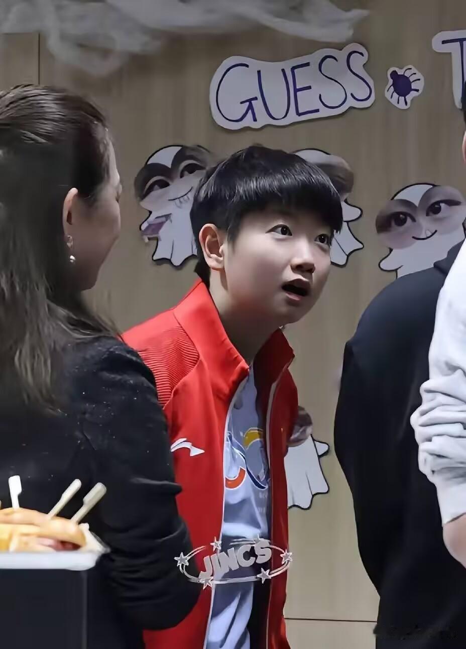 莎莎被逗得一脸惊讶，睁大眼睛看着变形贴纸连声问：“我长这样吗？”，模样特别可爱。