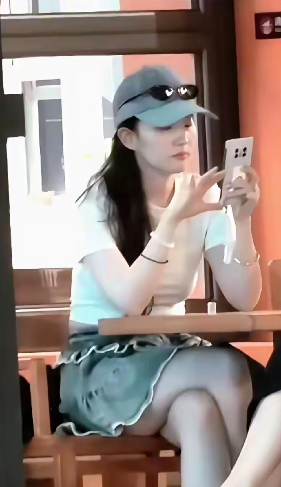 刘亦菲现身北京环球影城被偶遇，她身穿白色短袖，牛仔短裙，戴着鸭舌帽，皮肤皙白，好