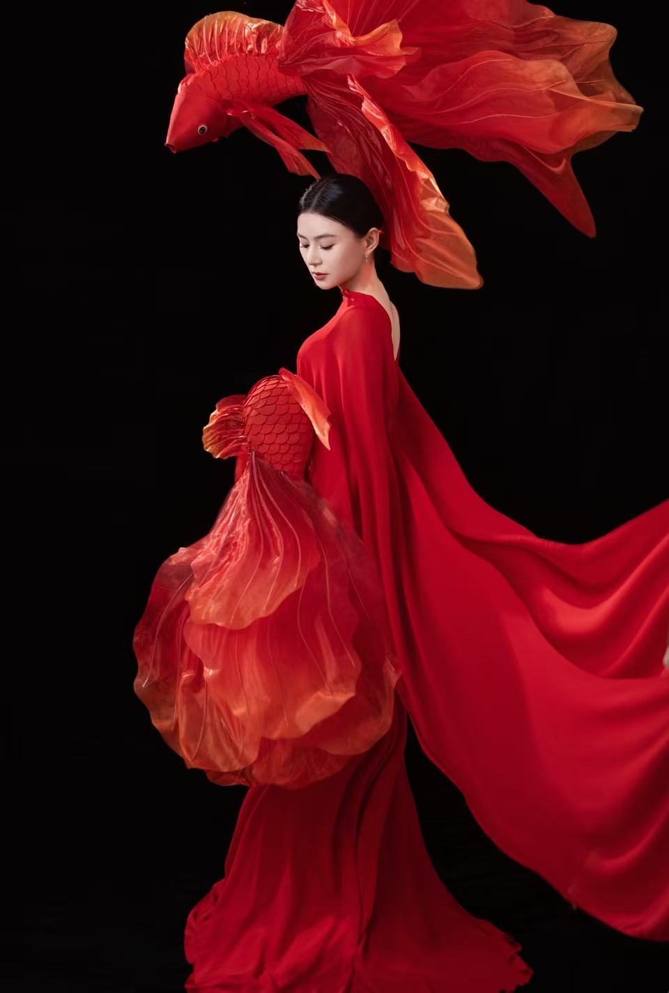 演员 元旦晒出的新年写真也太有韵味了吧！一袭红裙优雅又明艳，和灵动的红鲤意象呼应